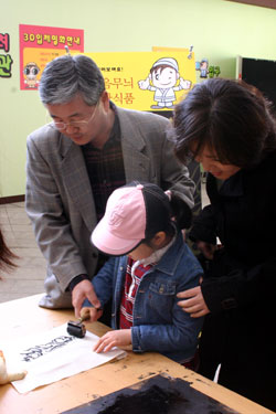 ▲  오정균(사진 왼쪽)서대전세무서장이 아내 및 딸과 함께 전시장 내 체험코너에 참가하고 있다.