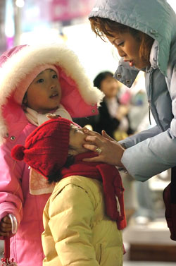 ▲  한파와 母情…   28일 오후부터 강한 바람과 함께 세찬 비가 몰아친 뒤 밤기온이 떨어지자 대전 으능정이 거리에서 한 가족의 엄마가 아이의 옷깃을 매만져 주고 있다.    지영철 기자