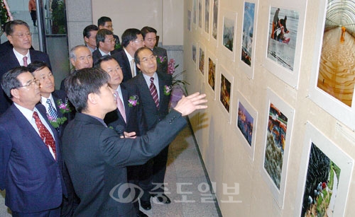 ▲  2005 대전. 충남보도사진전이 20일 대전시청 1층 전시실에서 열려 이중호(중도일보 사진부장) 한국사진기자협회 대전. 충남지회장이 박성효 대전시 정무부시장, 황진산 의장, 오광록 교육감, 김원식 중도일보사장, 조준호 대전일보사장, 변평섭 충청투데이회장, 이상윤 한남대총장, 김주일 상공회의소회장 등 내빈들에게 작품설명을 하고 있다.     박갑순 기자