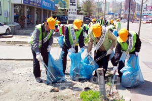 ▲  은빛자원봉사대 소속 노인들이 지난 22일 시내 중심 도로변에서 쓰레기와 재활용품 등을 줍고 있다.