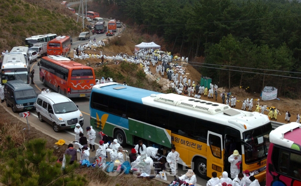 ▲ 27일 태안지역에 방재단 자원봉사자들이 대거로 참석하면서 방재작업을 하는 해안가도로가 휴가철 성수기때 보다 붐빈가운데 태안군 의항리 십리포 해수욕장 인근 해안도로가 관광버스와 방재단이 몰리면서 크게 붐벼 도로가 주차장화 됐다./특별취재반