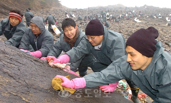 ▲ 7일 이랜드그룹 뉴코아 2001 아울렛소속 직원들이 태안군 원북면 황촌리 일원에서 바위 틈사이의 기름제거작업을 하고 있다.	/특별취재반