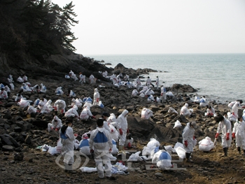 ▲ 신세계 백화점 죽전점 직원들이 17일 태안군 소원면 백리포 해안에서 바위에 묻은 기름을 닦아내고 있다.