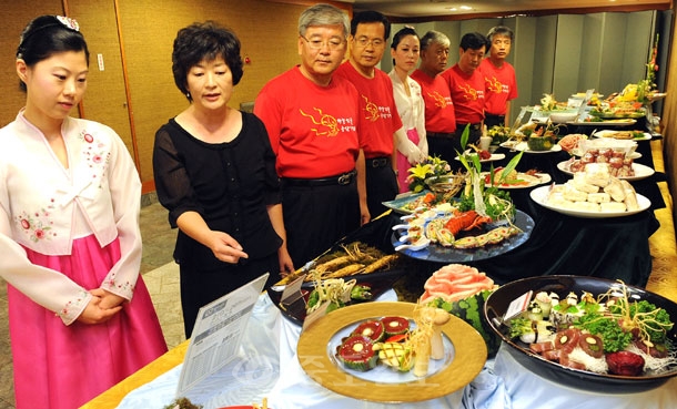 ▲ 금산인삼축제 공동마케팅 협약식이 열린 21일 대전 유성호텔에서 열리고 있는 '인삼테마음식 전시회'를 찾은 관광객과 금산군 관계자들이 인삼요리를 살펴보고 있다./지영철 기자 YCJI07@