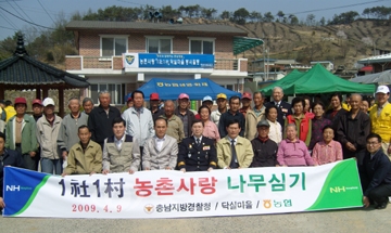 ▲ 농협중앙회 충남지역본부는 9일 충남 금산국 닥실마을에서 1사1촌을 맺은 충남지방경찰청과 닥실마을 주민들이 참여한 가운데 나무심기 행사를 벌였다.