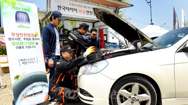 ▲ 한국타이어 관계자들이 4일 충남 태안군 안면읍 박람회장 제3주차장에서 안면도 국제꽃박람회를 찾은 관람객들의 안전운행을 위해 타이어를 비롯한 차량 안전점검을 무상으로 서비스 해주고 있다./태안=이민희 기자 photomin@