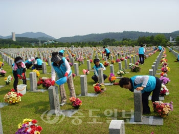 ▲ 지난해 현충원을 찾은 김형태 총장이 학생들과 함께 묘역 주변을 청소하고 있다.