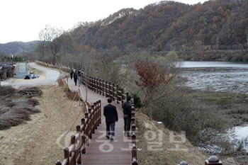 ▲ 대덕구가 1단계 공사를 마친 산책로인 '로하스 해피로드'가 대청호의 맑은물과 잔디밭과 어우러져 새로운 명소가 되고 있다. 사진은 주민들이 로하스 해피로드를 걸으며 산책하는 모습.