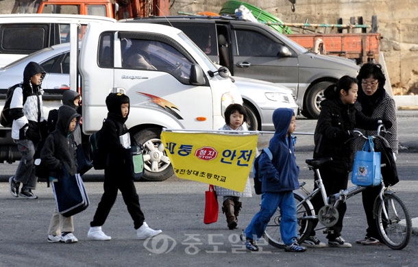 ▲ 대전상대초등학교 인근에서 학생들의 안전을 무시한채 공사가 진행되고 있어 원성을 사고 있다. 16일 오전 차도와 인도 구분이 없는 공사장을 지나는 학생들의 안전을 위해 선생님들이 교통안내를 하고 있다./이민희 기자