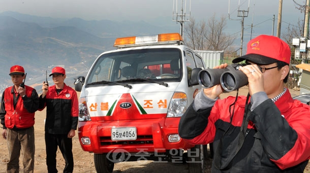 ▲ 봄철 건조기를맞아 대전동구청 산림계직원과 감시원들이 대전시와 인근 야산이 내려다 보이는 식장산 정상의 산불초소 앞에서 잠시도 긴장을 늦추지 않고 시시각각 망원경으로 철저한 감시 활동을 펼치고 있다. /김상구 기자