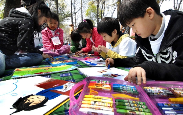 ▲ 2010 한국타이어 주부백일장 및 자녀사생대회가 24일 한구타이어 대전공장에서 열려 따듯한 봄날씨속에 가족과 함께 찾은 어린이들이 옹기종기 모여 그림을 그리기고 있다./이민희 기자