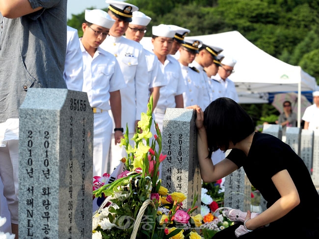 ▲  현충일인 6일 국립대전현충원 천안함 46용사 합동묘역을 찾은 천안함 생존장병들이 고인의 묘비 앞에서 오열하는 유가족을 지켜보고 있다./지영철 기자