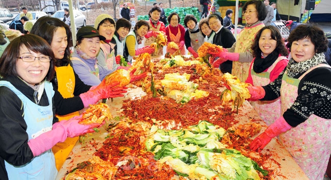 ▲ 사랑의 김장담그기 행사가 25일 노은시장에서 열려 행사에 참여한 시민들이 김치를 들어보이고있다./손인중 기자 dlswnd98@