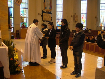 김정수 천안 신부동 성당 신부가 오기선 요셉장학금을 받는 학생들에게 장학금을 수여하고 있다. 