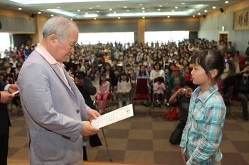 이인구 계룡장학재단 이사장이 유림공원사생대회 수상자에게 상장을 전달하고 있다. 