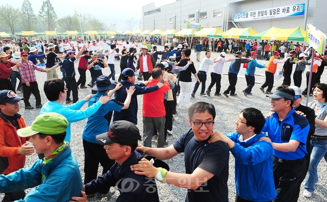 ▲ 지난 28일 충남도청 직원들이 홍성 내포신도시 아파트 모델하우스 주차장에서 성공적인 건설을 기원하며 어깨에 손을 얹고 행진하고 있다.<사진제공=충남도>