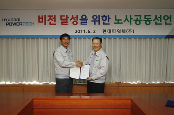 현대파워텍 배인규 대표이사(사진 오른쪽)와 김재경 사원대표가 노사공동선언문을 발표한 뒤 악수를 나누고 있다. 