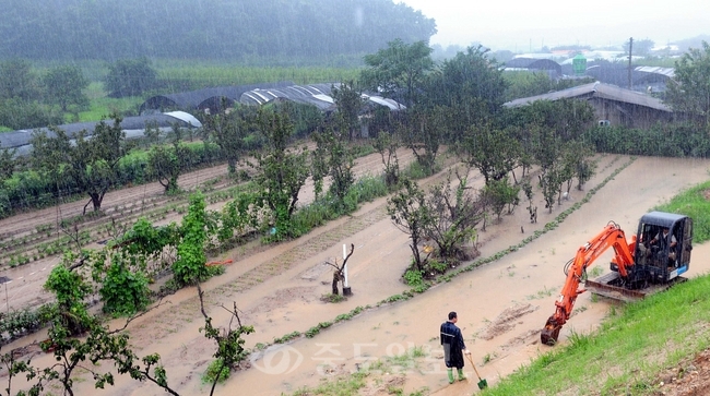 ▲ 대전·충남지역에 사흘째 장맛비가 퍼붓고있는 가운데 10일 유성구 용계동에 위치한 주택가와 논밭이 침수돼 중장비를 동원해 고인 물을 퍼내고 있다./손인중 기자