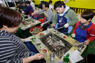 ▲ 지난해 천북굴축제를 찾은 관광객들이 굴구이를 맛보고  있다. 