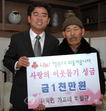 ▲공주 사곡면 가교리 박필규<사진 오른쪽>씨가 불우이웃돕기 성금 1000만원을 기탁했다. 