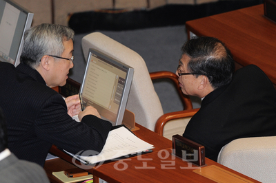 ▲22일 오후 서울 영등포 국회에서 열린 본회의에 출석한 김황식<사진 오른쪽> 국무총리가 현안질문 답변에 앞서 김성환 외교통상부 장관과 논의하고 있다. [뉴시스 제공]