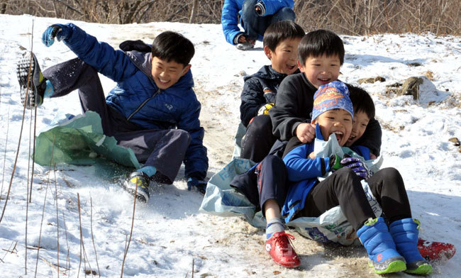 ▲ 2일 논산시 연산면 송정리의 눈이 쌓인 야산에서 마을 어린이들이 비료포대를 들고 나와 신나게 눈썰매를 즐기고 있다. 논산=손인중 기자 dlswnd98@