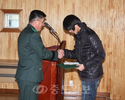 ▲ 육군항공학교장이 노성중학교 양찬규 군에게 상장과 장학금을 전달하고 있다.