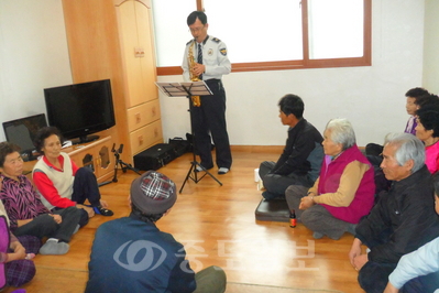 ▲ 추교일 경관이 지난달 5일 부여군 은산면의 한 마을회관에서 노인들에게 색소폰연주로 웃음치료를 하고 있다.