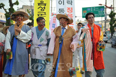 ▲ 사진은 이필용 음성군수<사진 오른쪽에서 두번째>가 품바 복장을 한채 지역 주민과 거리를 걷고 있는 모습.