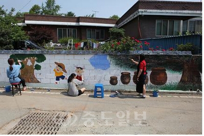 ▲ 공주 금성여고와 영명고의 미술통합동아리 '그린나래' 학생들이 공주시 우성면 대성리 대문안마을에 벽화 그리기 봉사활동을 펼치고 있다.