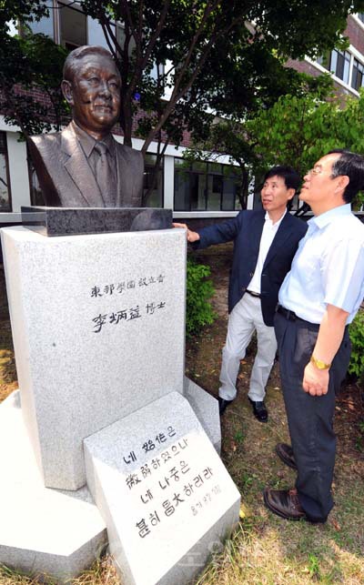 ▲동방고 최영복 교장<사진 왼쪽>과 손창옥 교감이 동방학원 설립자인 이병익 장로 동상 앞에서 재단 건학정신을 설명하고 있다. 