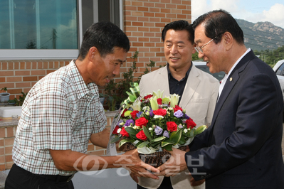 ▲ 김석환<사진 맨 오른쪽> 홍성군수가 30일 이성진의 부친 이범웅씨에게 축하 꽃다발을 전하고 있다.