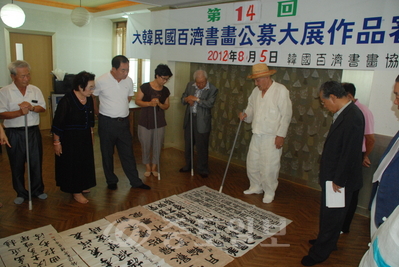 ▲ 한국백제서화협회(회장 이현자)의 주관으로 열린 14회 대한민국백제서화 공모대전 출품작들을 송암 민복기<왼쪽 여섯 번째> 심사위원장을 비롯한 위원들이 작품을 살펴보고 있다.