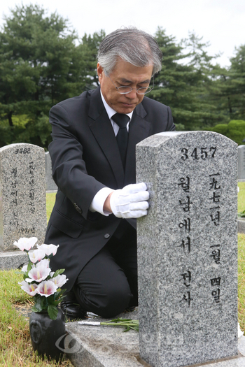 ▲ 사병묘역 참배하는 문재인 후보  문재인 민주통합당 대선후보가 17일 오전 동작동 국립서울현충원 사병묘역에서 월남전에서 사망한 고 김광민 하사의 묘에 헌화한 뒤 비석을 어루만지며 고인을 추모하고 있다. [연합뉴스 제공]