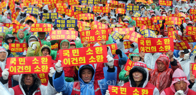 ▲ 서해안 유류피해민 총연합회 회원들이 3일 오후 서울 서초동 삼성본관 앞에서 열린 상경집회에서 '국민 소환, 이건희 소환'이라고 적힌 손팻말을 들고 구호를 외치고 있다. 이들은 집회에서 삼성중공업이 2007년 기름유출사고로 피해를 본 태안 지역 주민들에게 책임 있는 보상을 하라고 촉구했다.  
<br />연합사진