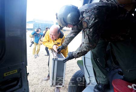 ▲ 한국원자력안전기술원(KINS) 한 연구원이 14일 헬기로 옮겨진 2, 3차 포집한 시료를 군 장병으로부터 건네받고 있다. [연합뉴스 제공]