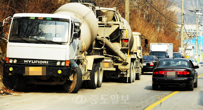 ▲ 6일 대전시 대덕구 대화공단 주변 도로에 대형차량들이 주정차하는 상황이 계속되면서 이곳을 이동하는 운전자들이 중앙선을 침범하는 등 사고 위험이 높아 조속한 안전조치가 필요하다. 
<br />이민희 기자 photomin@