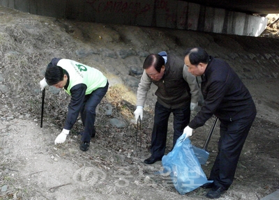 ▲ 김길동 농협 천안시지부장이 성무용 천안시장과 함께 신부동 하천변에서 환경정화 활동을 하고 있다.