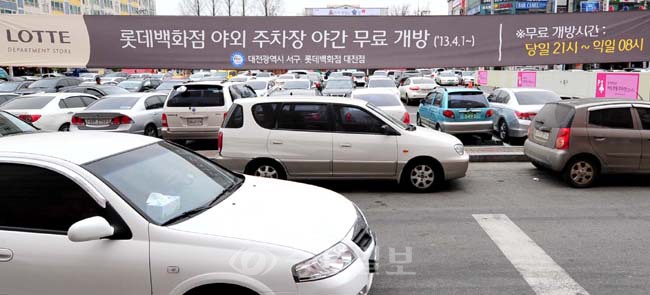 ▲ 저녁 8시 이후 텅 비어있던 롯데백화점 야외 주차장이 주변 상권과 시민들을 위해 개방을 앞두고 있는 가운데 무료개방을 알리는 현수막이 내걸려 있다.
<br />손인중 기자