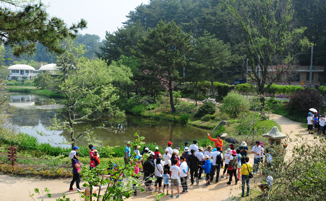 ▲ 중도일보와 충남도가 공동주최한 '행복충만! 서해바다 힐링 자동차투어'가 지난 24일부터 26일까지 2박3일간 열린 가운데 투어 이틀째인 25일 참가자들이 천리포 수목원을 방문해 숲 해설사의 설명을 듣고 있다. 박갑순 기자