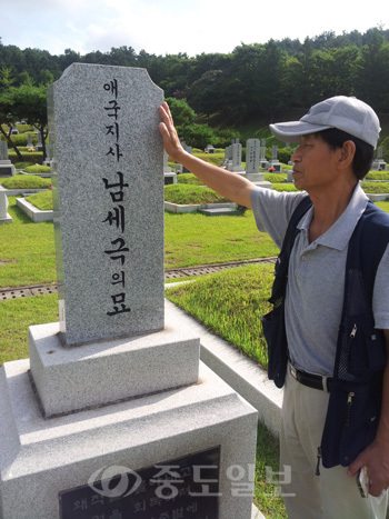 남세극 애국지사의 조카 손자 남상우씨가 15일 남 지사의 묘비를 어루만지면서 고인을 추모하고 있다.