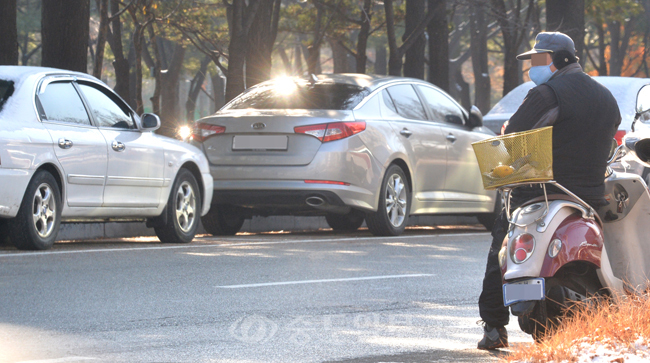 ▲ 영하권의 추운 날씨를 보인 12일 대전시청 앞 공영 노상주차장에서 요금 징수요원이 오토바이 위에 앉아 잠시 쉬고 있다. 
<br />이성희 기자 token77@