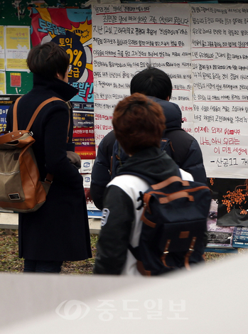 ▲  16일 대전 유성구 KAIST 태울관 입구에 붙은 '안녕하지 못합니다'라는 제목의 대자보를 학생들이 읽고 있다. 사회현안에 대한 관심을 촉구하는 '안녕들 하십니까' 벽보 바람은 고대에서 시작해 전국 대학가와 고교로 확산하고 있다. 
<br />연합뉴스