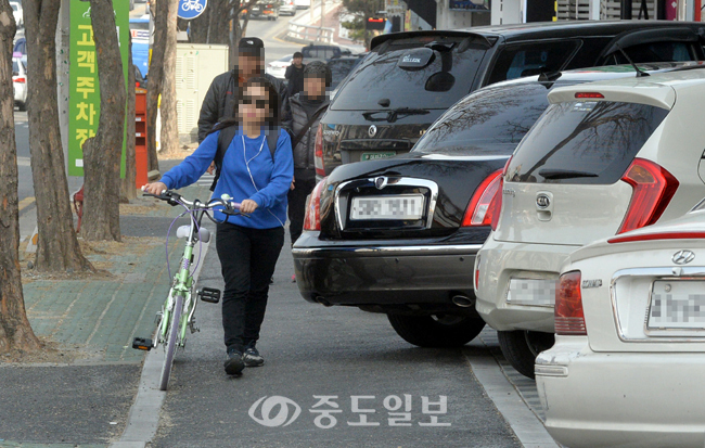 ▲ 자전거 이용객을 위해 조성된 자전거도로가 불법 주차로 몸살을 앓고 있는 가운데 18일 대전 서구 탄방동에서 한 시민이 주차차량에 막혀 자전거를 끌고 가고 있다.
<br /> 이성희 기자 token77@