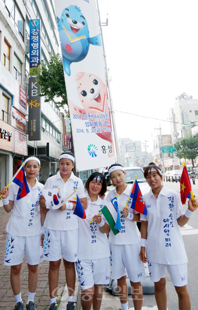 ▲ 다문화가족 성화봉송 주자들이 각각 태극기와 자국의 국기를 들고 기념촬영하고 있다.