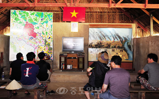 ▲ 한국인 관광객들이 구찌터널 관람전에 전쟁당시 상황을 설명하는 한국어 영상을 보고 있다.
<br />