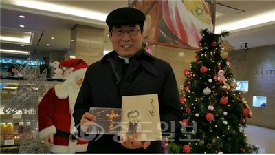 ▲ 신간 그림움의 향기와 플루트 연주 CD를 들고  있는 김정수 신부.