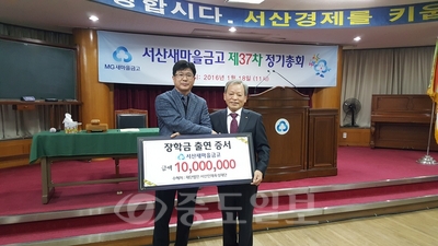 김정한 서산새마을금고 이사장이 유장곤 서산인재육성 재단 이사에게 장학금 1000만원을 기탁하고 있다.