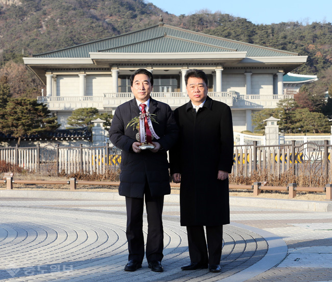 ▲ 더불어민주당 박수현 비대위원장 비서실장과 김성수 대변인이 2일 청와대 분수대 앞에서 김종인 비상대책위원장이 박근혜 대통령에게 보낸 생일축하 난을 들어 보이고 있다.
<br />연합뉴스