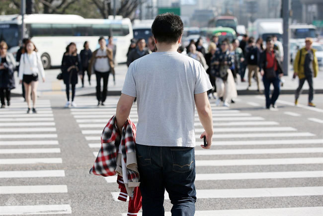 ▲완연한 봄날씨를 보인 30일 오후 서울 광화문에 한 시민이 외투를 벗어 들고 걸어가고 있다. 연합뉴스